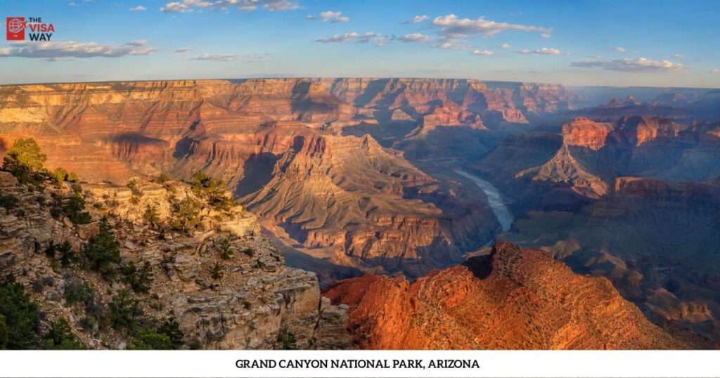 Grand Canyon National Park in Arizona with the Colorado River flowing through sunlit red rock formations